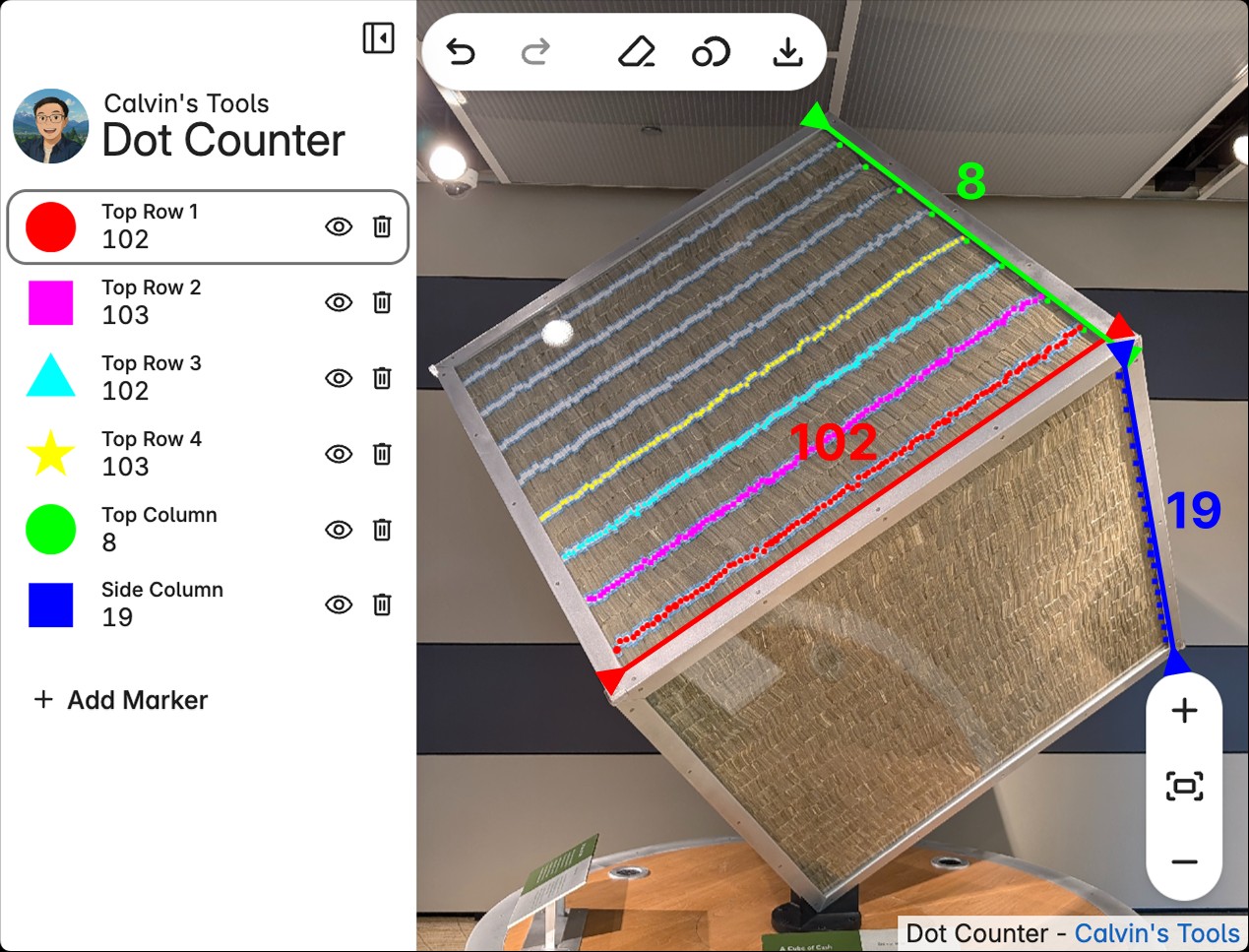 A large transparent cube filled with stacks of $1 bills is displayed at the Federal Reserve Bank of Chicago's Money Museum. The cube is labeled as containing one million dollars. Overlaid on the image are colored annotations measuring the cube’s dimensions: the red diagonal face is labeled "102", the blue vertical edge is labeled "19", and the green horizontal edge is labeled "8". These measurements represent the number of bill stacks in each dimension, indicating the cube holds significantly more than one million dollars.